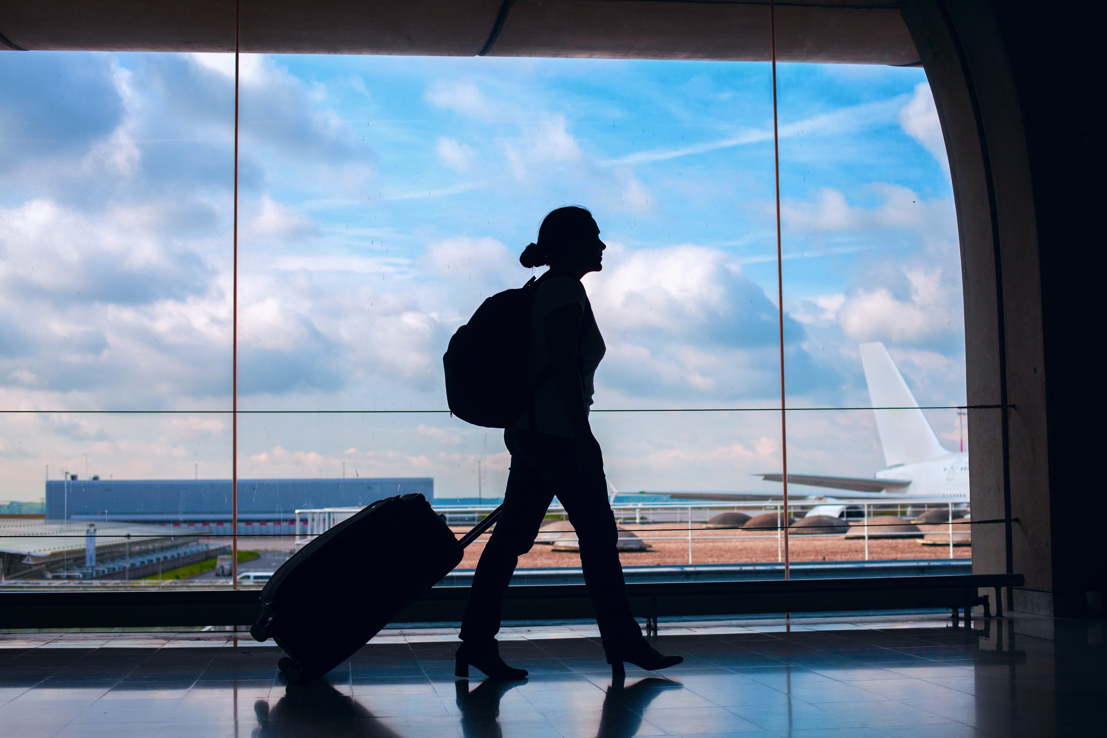 Traveler with luggage at the airport near ground transportation